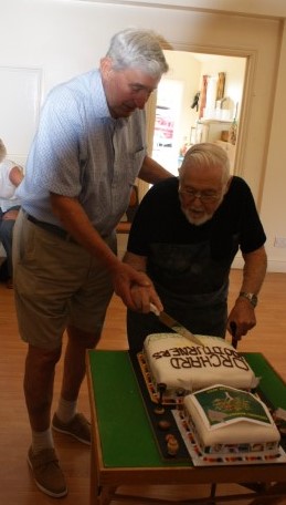 Two founder members Norman and Bert cutting the anniversary cake